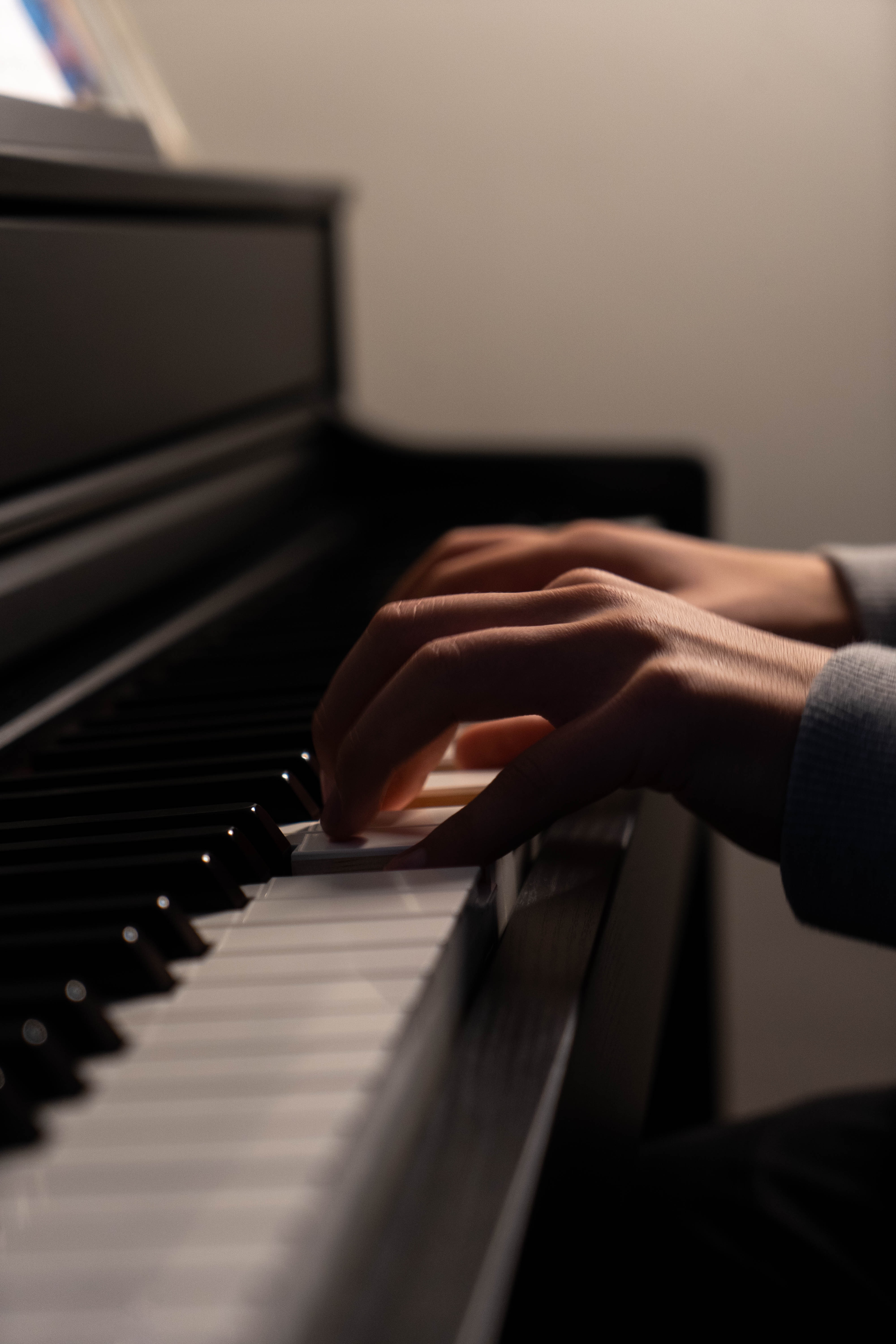 Sharp cinematic close-up of a grand piano keyboard with gold lighting reflections